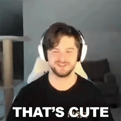 A Man Wearing Headphones Is Smiling And Saying `` That 'S Cute '' While Sitting In A Chair . GIF