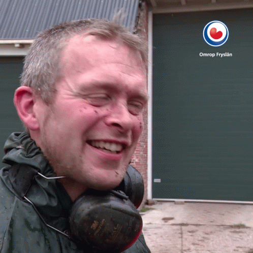 A Man Wearing Headphones Is Smiling In Front Of An Omrop Fryslan Logo GIF