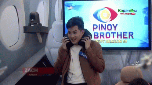 A Man Wearing Headphones Is Standing In Front Of A Screen That Says Pinoy Brother GIF