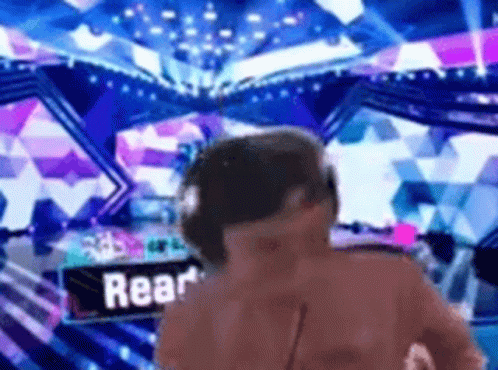 A Man Wearing Headphones Is Standing In Front Of A Sign That Says Rear On It . GIF