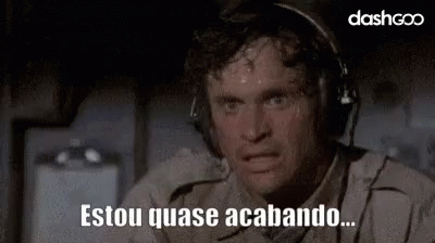 A Man Wearing Headphones Is Sweating And Making A Funny Face While Sitting On A Plane . GIF