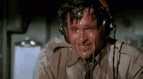 A Man Wearing Headphones Is Sweating While Sitting In A Plane . GIF