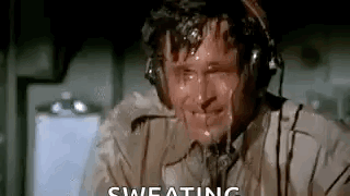 A Man Wearing Headphones Is Sweating While Sitting In An Airplane Cockpit . GIF