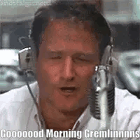A Man Wearing Headphones Is Talking Into A Microphone And Saying Good Morning Gremlins . GIF