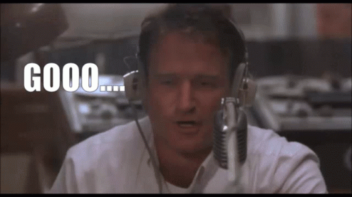 A Man Wearing Headphones Is Talking Into A Microphone And The Words Good Are Above Him GIF