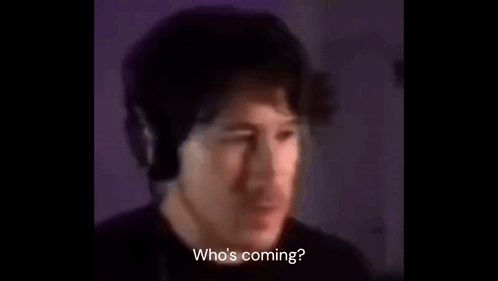 A Man Wearing Headphones Is Talking Into A Microphone In A Dark Room . GIF