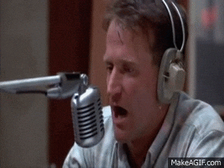 A Man Wearing Headphones Is Talking Into A Microphone .. GIF