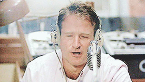 A Man Wearing Headphones Is Talking Into A Microphone With His Eyes Closed GIF