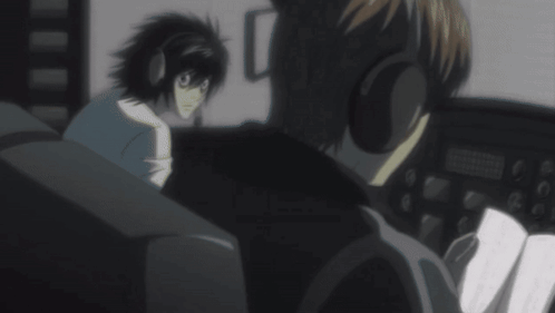 A Man Wearing Headphones Is Talking To Another Man In A Dark Room GIF