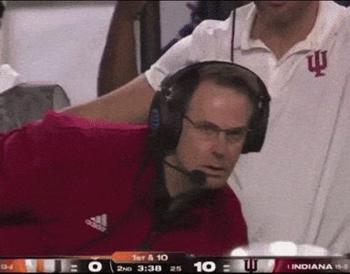 A Man Wearing Headphones Is Watching A Football Game Between Indiana And Iowa GIF