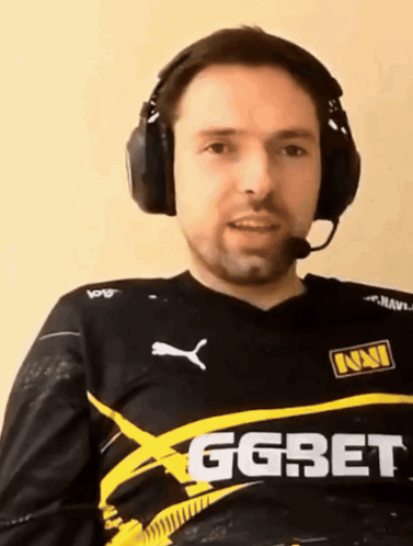 A Man Wearing Headphones Is Wearing A Shirt That Says Ggbet GIF