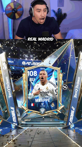A Man Wearing Headphones Looks At A Card That Says Real Madrid On It GIF