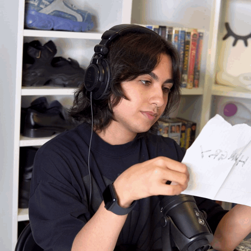 A Man Wearing Headphones Looks At A Piece Of Paper That Says ' Hash ' GIF