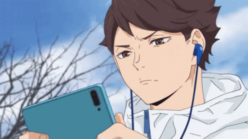 A Man Wearing Headphones Looks At His Phone GIF