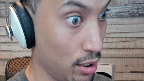 A Man Wearing Headphones Looks Surprised With His Mouth Open GIF