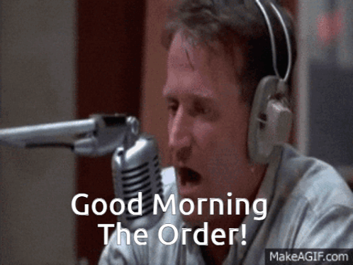 A Man Wearing Headphones Says " Good Morning The Order " In Front Of A Microphone GIF