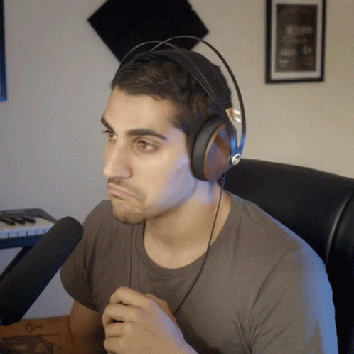 A Man Wearing Headphones Sitting In Front Of A Keyboard GIF