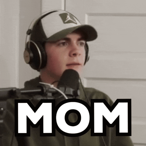 A Man Wearing Headphones Stands In Front Of A Microphone And Says Mom GIF