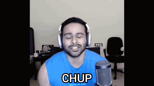 A Man Wearing Headphones Stands In Front Of A Microphone With The Word Chup On The Bottom GIF