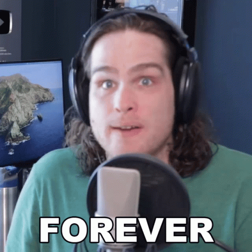 A Man Wearing Headphones Stands In Front Of A Microphone With The Word Forever On His Face GIF