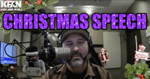 A Man Wearing Headphones Stands In Front Of A Microphone With The Words " Christmas Speech " Above Him GIF