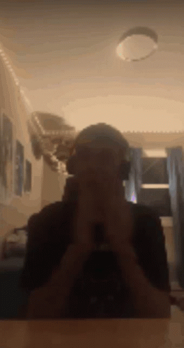 A Man Wearing Headphones Takes A Picture Of Himself In A Mirror . GIF