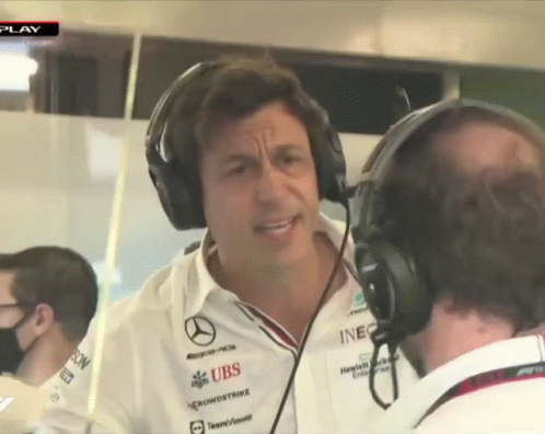 A Man Wearing Headphones Talks To Another Man Who Is Wearing A Shirt That Says Ubs GIF