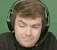 A Man Wearing Headphones With A Microphone On His Head Is Making A Funny Face . GIF