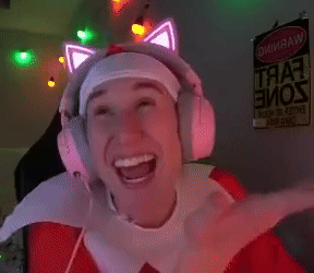 a man wearing headphones with glowing cat ears is smiling in front of a sign that says " warning "