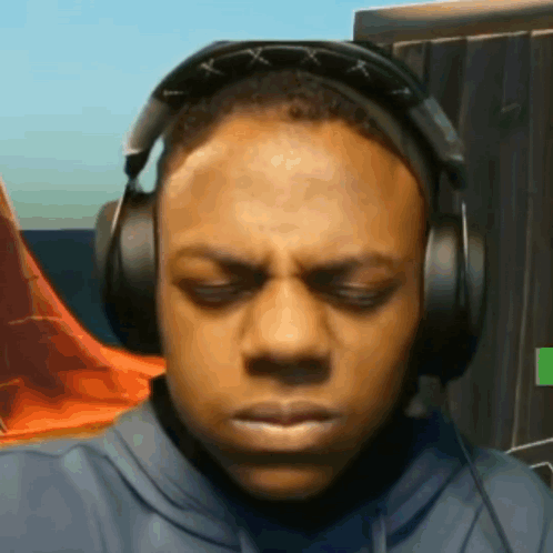 A Man Wearing Headphones With His Eyes Closed Is Making A Funny Face . GIF