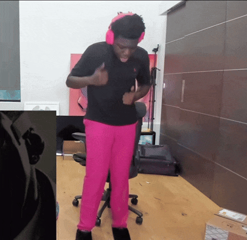 a man wearing pink pants and headphones is standing in a room