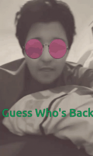 A Man Wearing Pink Sunglasses With The Words Guess Who 'S Back Above Him GIF