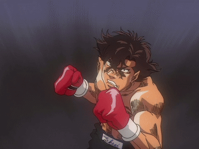 A Man Wearing Red Boxing Gloves Throws A Punch In A Dark Room GIF