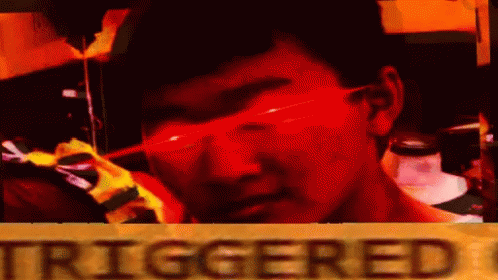 A Man Wearing Red Glasses Is Standing In Front Of A Sign That Says `` Triggered '' . GIF