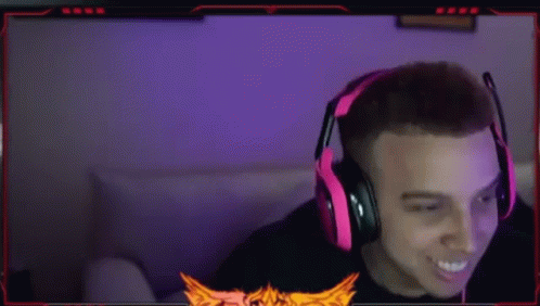 A Man Wearing Red Headphones Is Sitting In Front Of A Computer Monitor . GIF