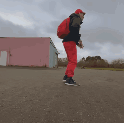 A Man Wearing Red Pants And A Red Backpack Is Jumping In The Air GIF