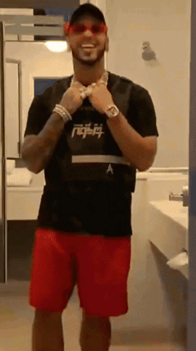 A Man Wearing Red Shorts And A Black Shirt With A Letter A On It GIF
