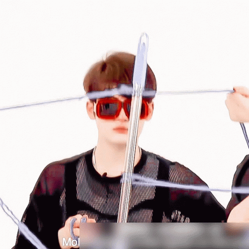 A Man Wearing Red Sunglasses Is Holding A Pen In His Hand GIF