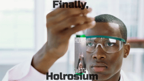 A Man Wearing Safety Goggles Holds A Bottle Of Holrosium GIF