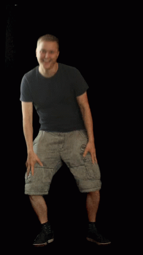 A Man Wearing Shorts And A Black Shirt Is Standing With His Hands On His Hips GIF