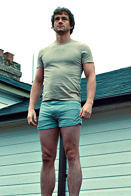 A Man Wearing Shorts And A T-Shirt Is Standing On A Pole GIF