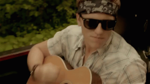 A Man Wearing Sunglasses And A Bandana Has A Guitar In His Right Hand GIF