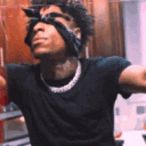 A Man Wearing Sunglasses And A Bandana On His Head Is Standing In Front Of A Mirror . GIF