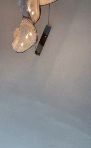 A Man Wearing Sunglasses And A Baseball Cap Is Standing In A Room . GIF