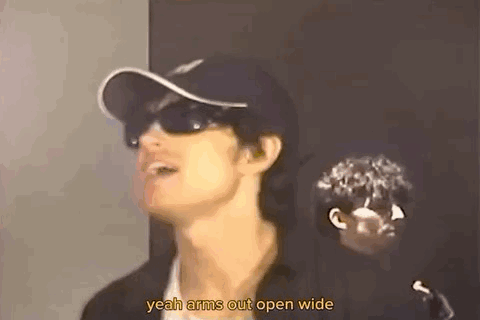 A Man Wearing Sunglasses And A Baseball Cap Is Talking . GIF