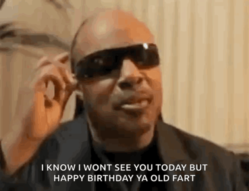 A Man Wearing Sunglasses And A Black Jacket Is Talking On A Cell Phone . GIF