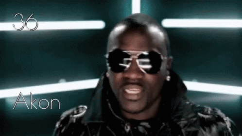 A Man Wearing Sunglasses And A Black Jacket With The Name Akon Written On The Bottom GIF