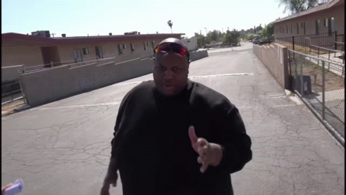 A Man Wearing Sunglasses And A Black Shirt Is Giving A Thumbs Up Sign GIF