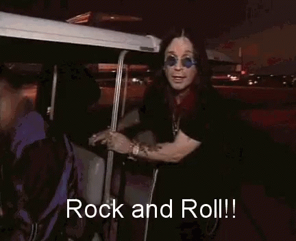 A Man Wearing Sunglasses And A Black Shirt Is Saying Rock And Roll GIF
