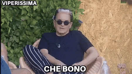 a man wearing sunglasses and a black shirt is sitting in a chair with the words che bono above him
